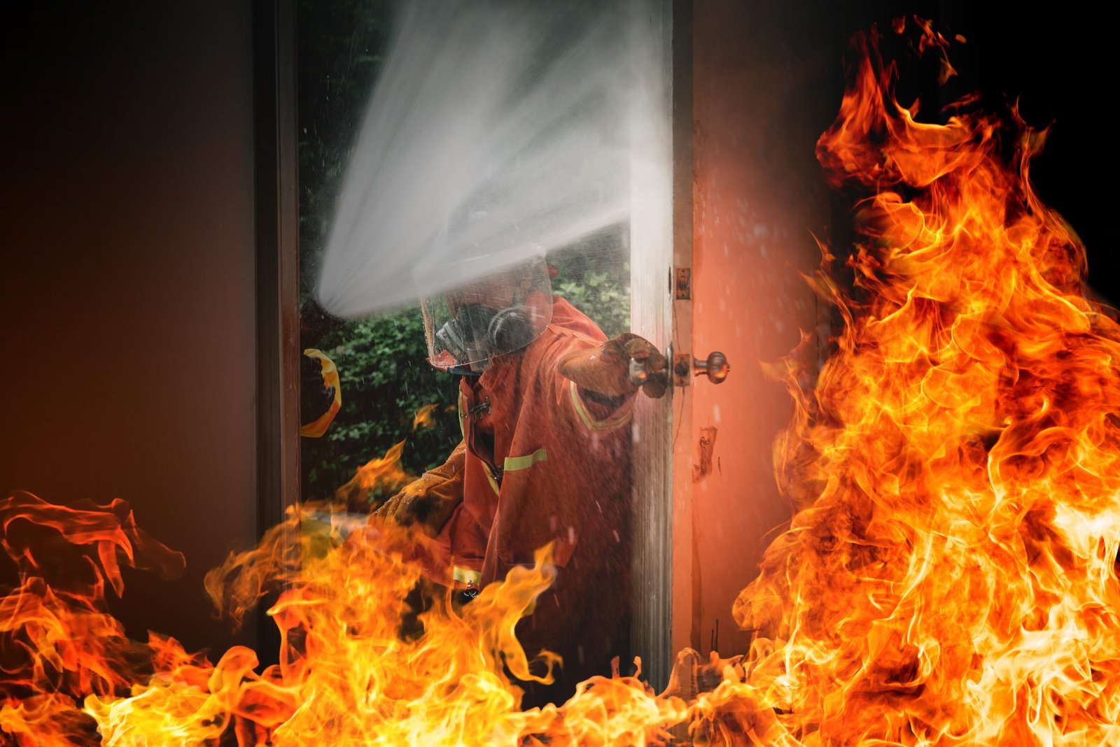 Firefighters controlling house fire.